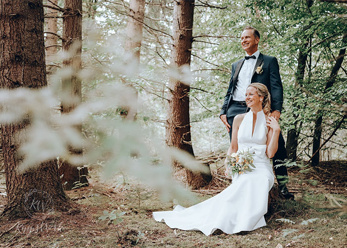 Hochzeitsreportage, Brautpaar steht im Wald hintereinander